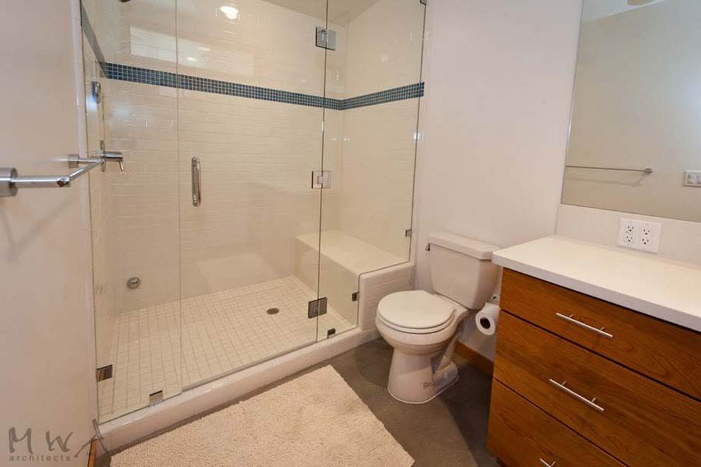 Inspiration for a mid-sized midcentury 3/4 bathroom in Sacramento with flat-panel cabinets, medium wood cabinets, a two-piece toilet, white tile, white walls, concrete floors and an alcove shower.