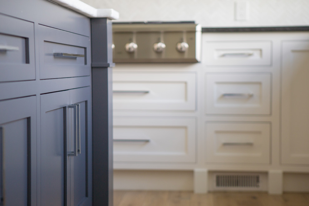 Mid-sized transitional u-shaped light wood floor and brown floor open concept kitchen photo in Baltimore with an undermount sink, shaker cabinets, blue cabinets, marble countertops, gray backsplash, marble backsplash, stainless steel appliances and an island