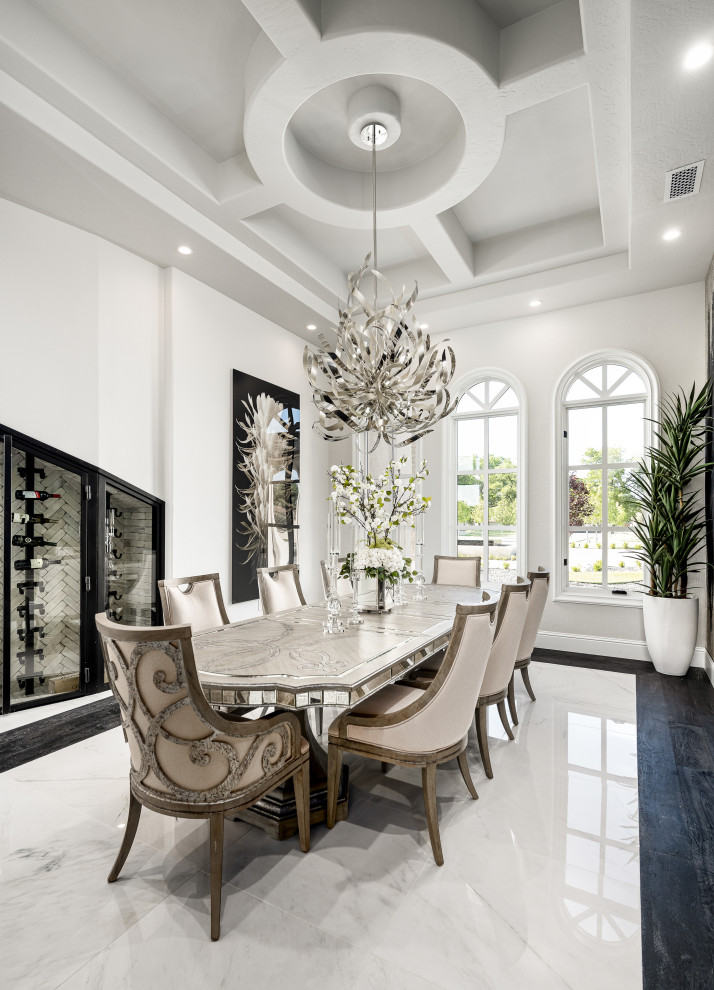 This is an example of an expansive modern open plan dining in Phoenix with white walls, marble floors, white floor and coffered.