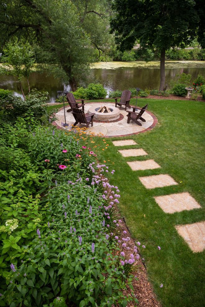 Photo of a small country backyard partial sun garden for summer in Milwaukee with a fire feature and natural stone pavers.