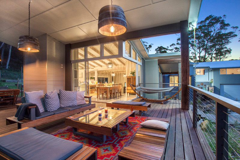 Large country backyard patio in Sydney with a fire feature, decking and a roof extension.