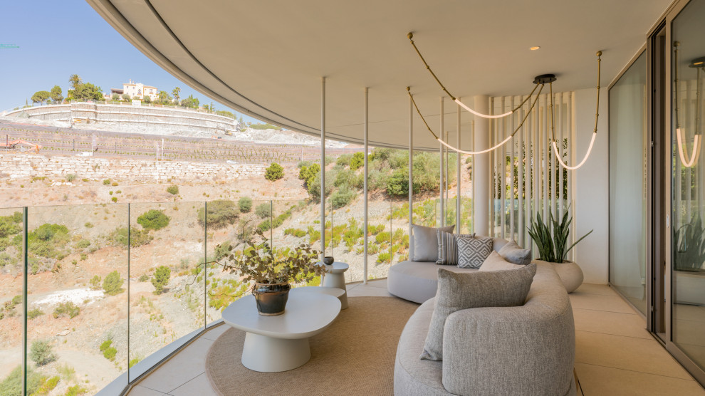 Trendy glass railing balcony photo with a roof extension