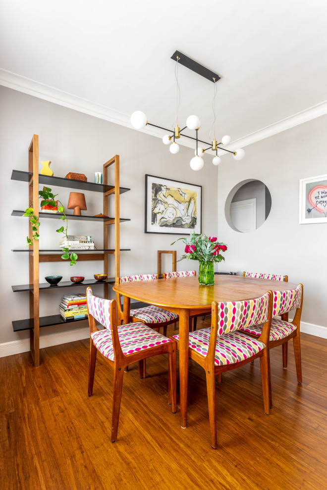 Esempio di una sala da pranzo aperta verso il soggiorno boho chic di medie dimensioni con pareti grigie, pavimento in bambù e pavimento marrone
