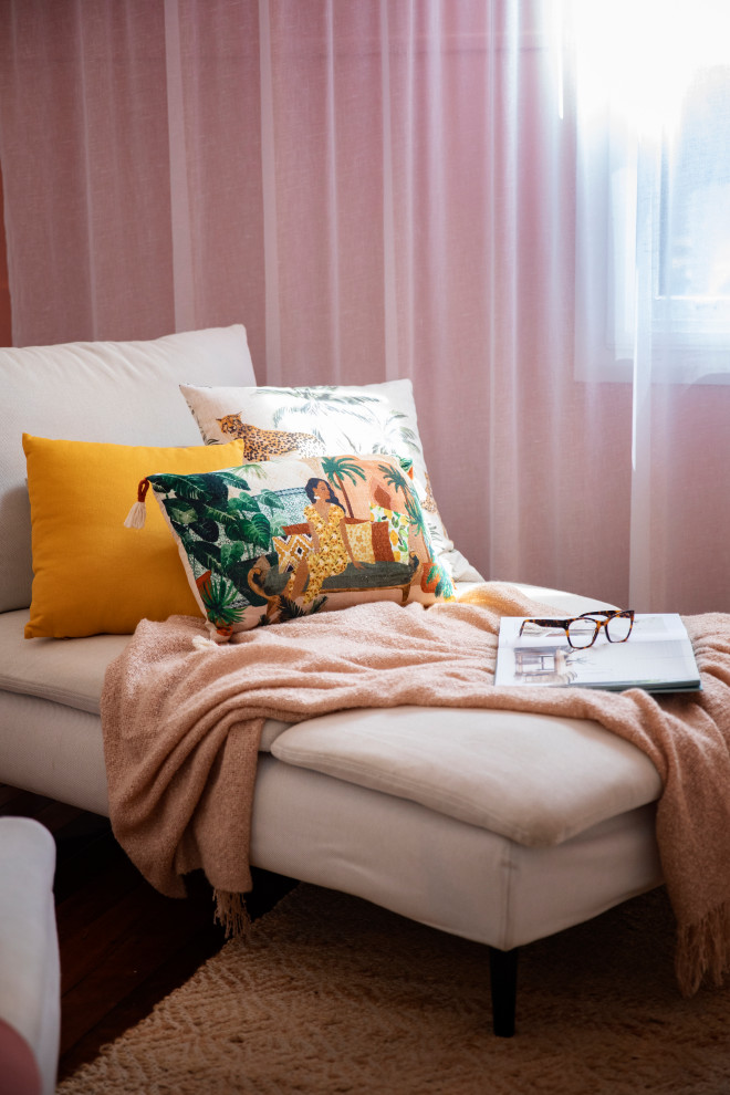 Modelo de salón abierto mediterráneo de tamaño medio con paredes rosas, suelo de madera oscura, televisor independiente y suelo marrón