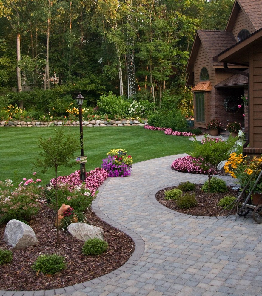 This is an example of a traditional full sun garden in Minneapolis with a garden path and brick pavers.