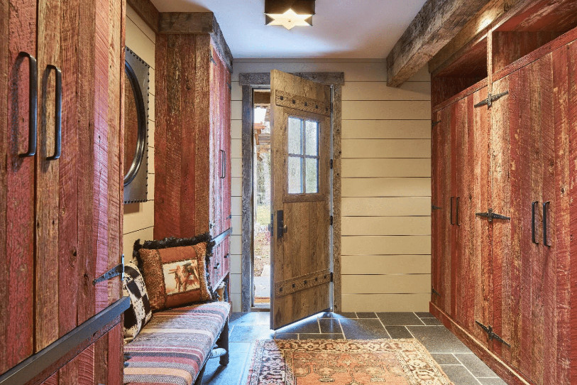Inspiration for a mid-sized rustic travertine floor and gray floor mudroom remodel with beige walls and a light wood front door