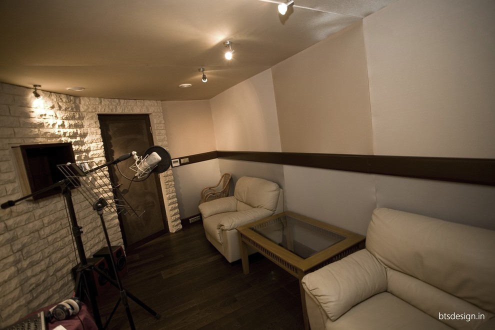 This is an example of a mid-sized transitional enclosed home theatre in Other with beige walls, painted wood floors, a projector screen and brown floor.