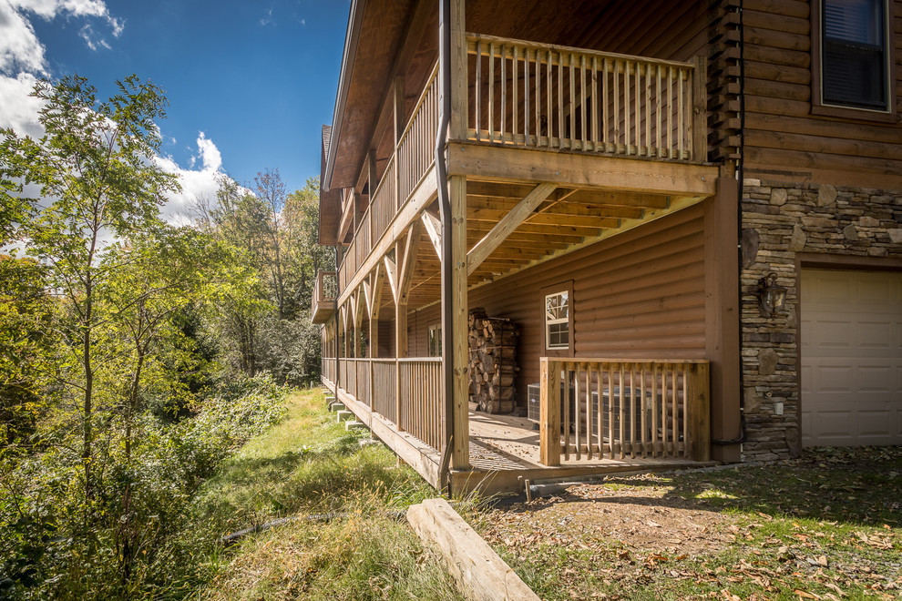 Deck - huge rustic backyard deck idea in Charlotte with a roof extension
