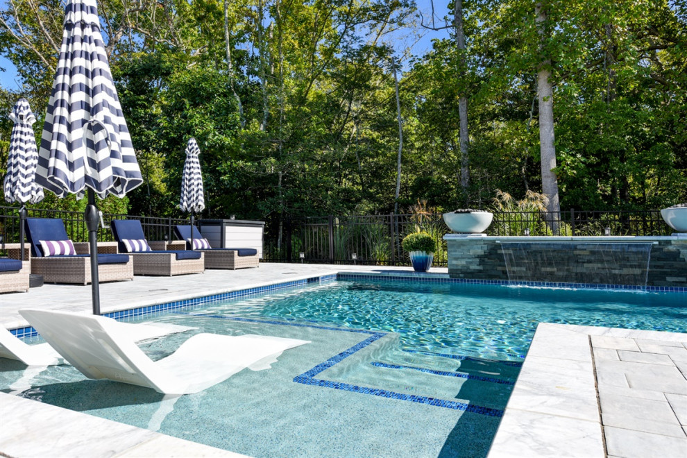 Photo of a mid-sized contemporary backyard l-shaped pool in Other with a water feature and concrete pavers.
