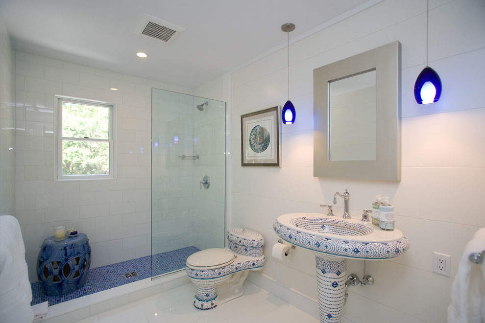 Photo of a transitional bathroom in New York with a pedestal sink, an open shower, white tile, white floor and an open shower.