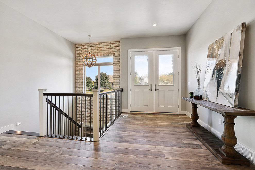 Inspiration for a large craftsman dark wood floor and brown floor foyer remodel with gray walls and a white front door