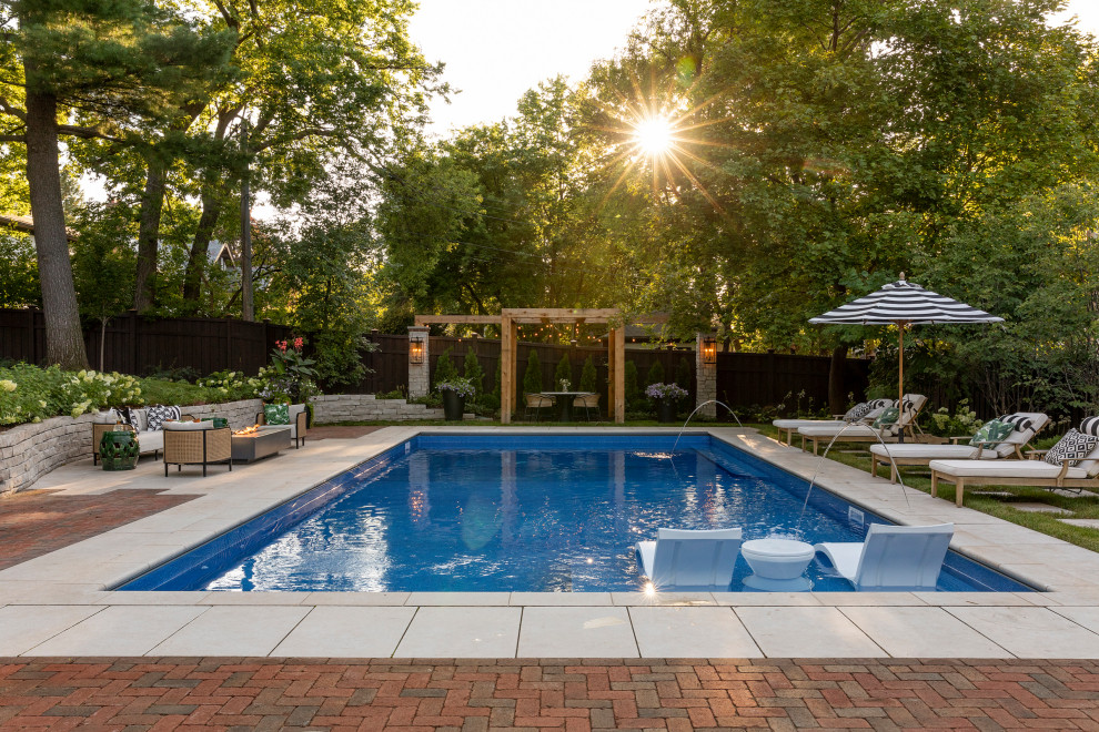Foto de piscina natural de estilo americano grande rectangular en patio trasero con paisajismo de piscina y adoquines de piedra natural