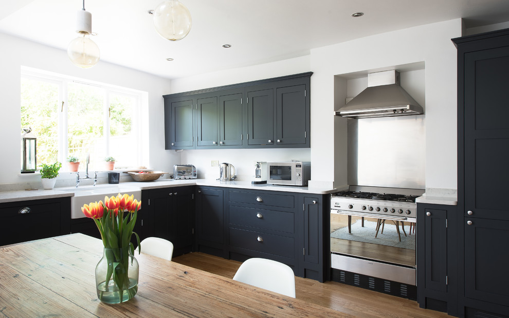 Inspiration for a small country eat-in kitchen in London with shaker cabinets, dark wood cabinets and light hardwood floors.