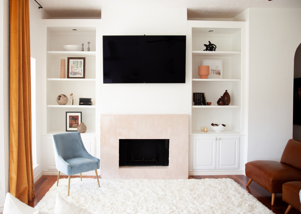 Mittelgroßes, Offenes Klassisches Wohnzimmer mit weißer Wandfarbe, dunklem Holzboden, Kamin, verputzter Kaminumrandung, Multimediawand und rotem Boden in Austin