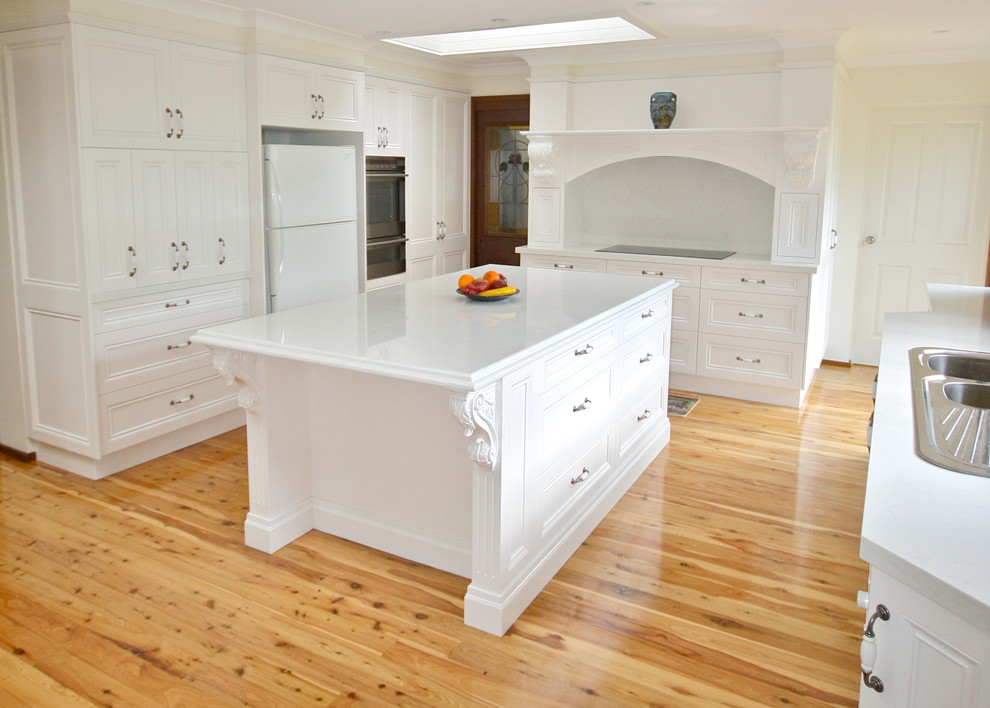 Design ideas for a large transitional u-shaped eat-in kitchen in Sydney with a drop-in sink, recessed-panel cabinets, white cabinets, marble benchtops, white splashback, stone slab splashback, stainless steel appliances, light hardwood floors and with island.