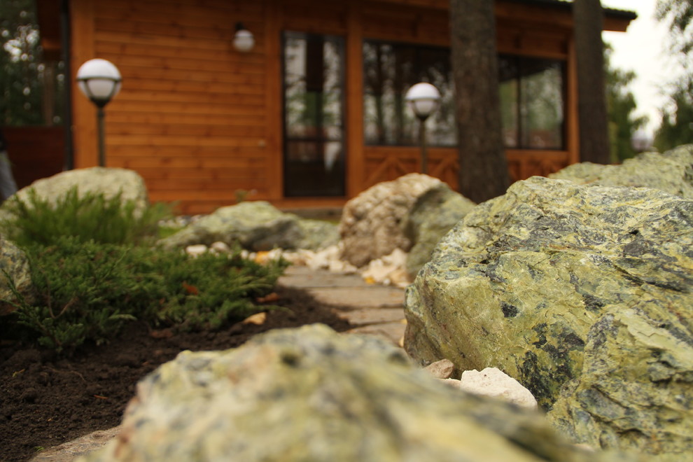 Цветник с камнями и композицией из кустарника