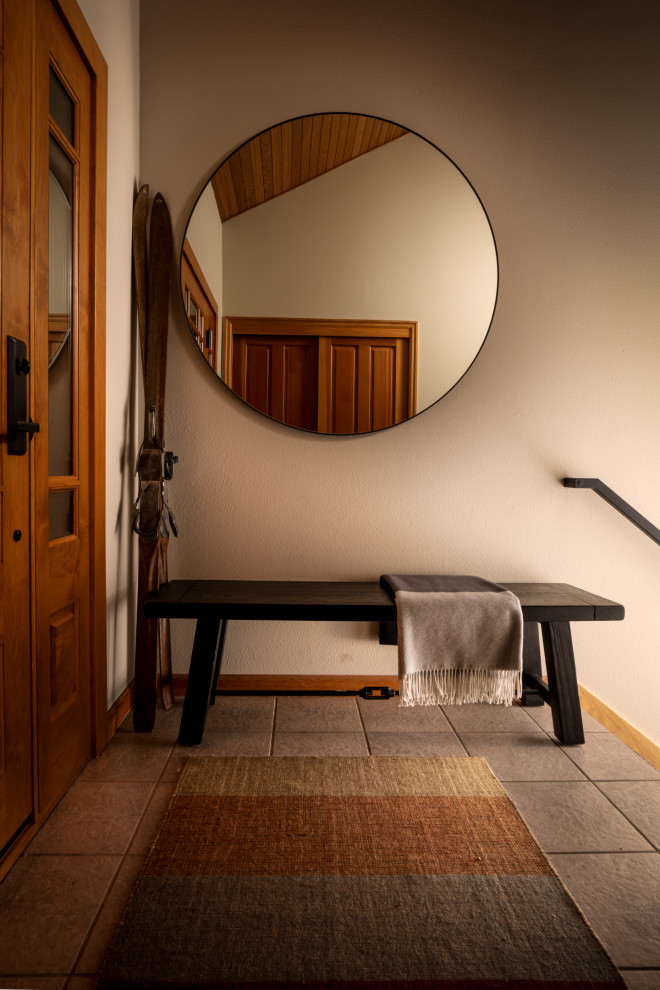 ポートランドにあるお手頃価格のトランジショナルスタイルのおしゃれな玄関ロビー (セラミックタイルの床、木目調のドア、三角天井) の写真