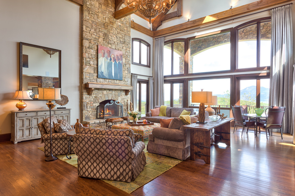Design ideas for a mid-sized country open concept living room in Charlotte with beige walls, medium hardwood floors, a standard fireplace and a stone fireplace surround.
