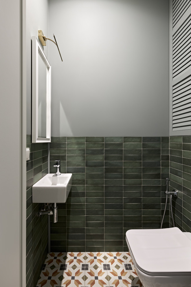 Источник вдохновения для домашнего уюта: маленький туалет в стиле неоклассика (современная классика) с открытыми фасадами, белыми фасадами, инсталляцией, зеленой плиткой, удлиненной плиткой, серыми стенами, полом из керамической плитки, подвесной раковиной, разноцветным полом, белой столешницей, напольной тумбой и обоями на стенах для на участке и в саду