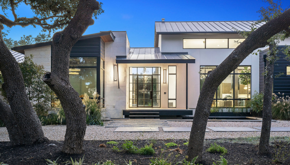 Diseño de fachada de casa actual de una planta con revestimientos combinados y tejado de metal