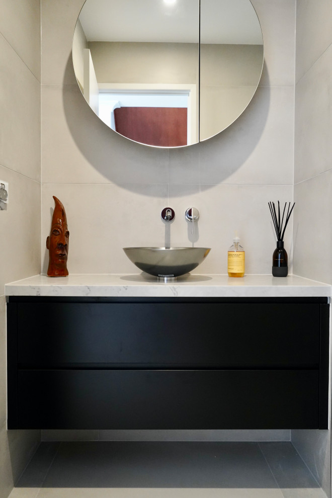 Esempio di una piccola stanza da bagno moderna con ante lisce, ante nere, pavimento in cementine, pavimento grigio, piastrelle grigie, piastrelle di cemento, top in quarzo composito, top grigio, un lavabo e mobile bagno sospeso