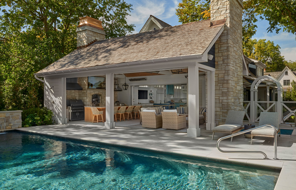 На фото: большой двор на заднем дворе в морском стиле с покрытием из каменной брусчатки, летней кухней и навесом