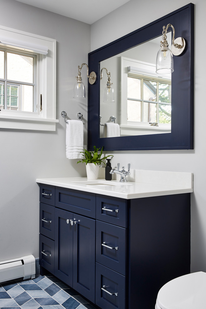 Photo of a mid-sized transitional powder room in Minneapolis with recessed-panel cabinets, black cabinets, an undermount sink, white benchtops and a built-in vanity.