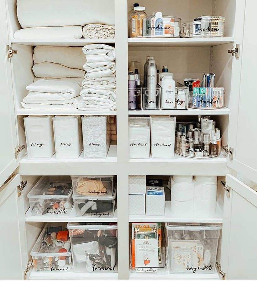 This is an example of a small country gender-neutral built-in wardrobe in New York with white cabinets, medium hardwood floors and brown floor.