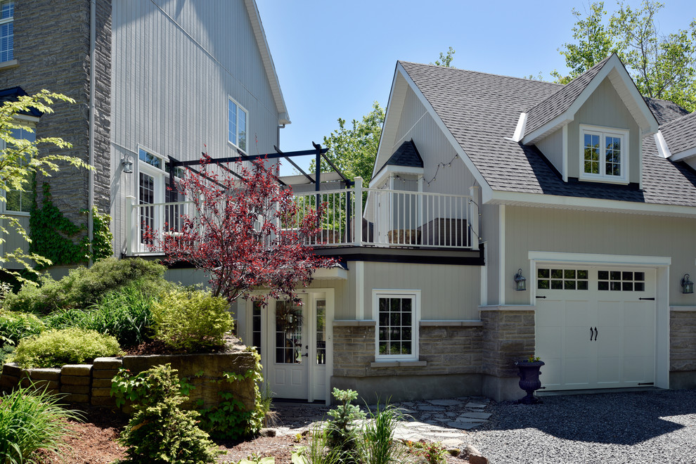 Photo of a large arts and crafts three-storey grey house exterior in Ottawa with mixed siding.