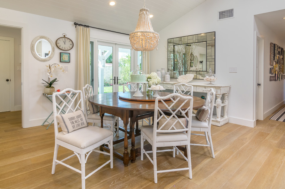 Beach style dining room in Other with white walls and light hardwood floors.