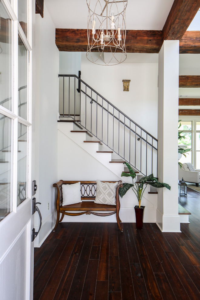 Photo of a large transitional foyer in New Orleans with white walls, dark hardwood floors, a single front door and a white front door.