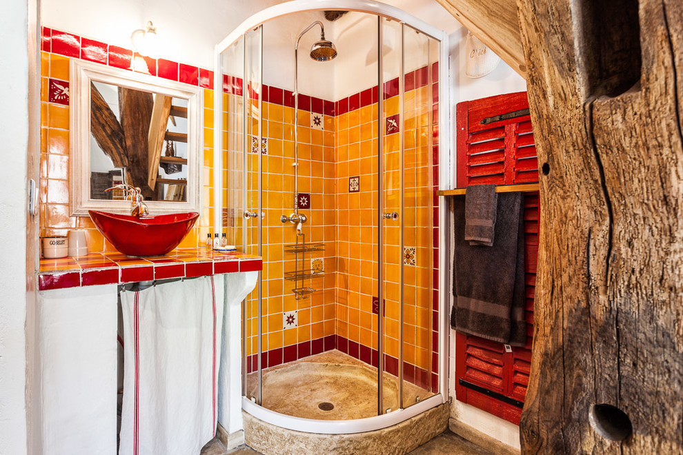 This is an example of a small mediterranean 3/4 bathroom in Marseille with a corner shower, orange tile, red tile, ceramic tile, a vessel sink, tile benchtops, open cabinets, white walls and a sliding shower screen.
