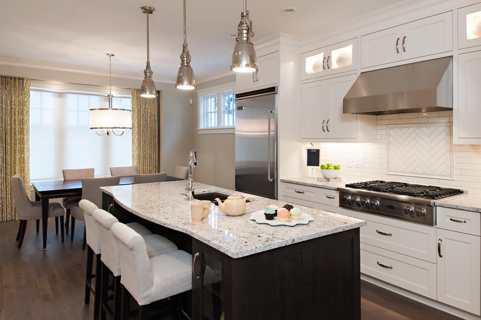 Design ideas for a mid-sized traditional galley separate kitchen in Calgary with an undermount sink, recessed-panel cabinets, white cabinets, granite benchtops, white splashback, ceramic splashback, stainless steel appliances, medium hardwood floors and with island.