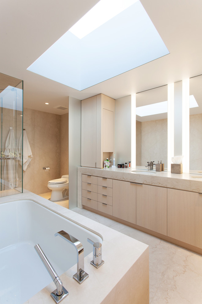 Inspiration for a large modern master bathroom in Chicago with flat-panel cabinets, light wood cabinets, a drop-in tub, a corner shower, beige tile and beige walls.