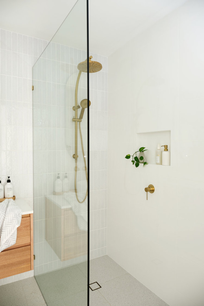 Design ideas for a small midcentury master bathroom in Los Angeles with flat-panel cabinets, medium wood cabinets, a corner shower, a one-piece toilet, white tile, porcelain tile, white walls, slate floors, a drop-in sink, laminate benchtops, beige floor, a hinged shower door and white benchtops.