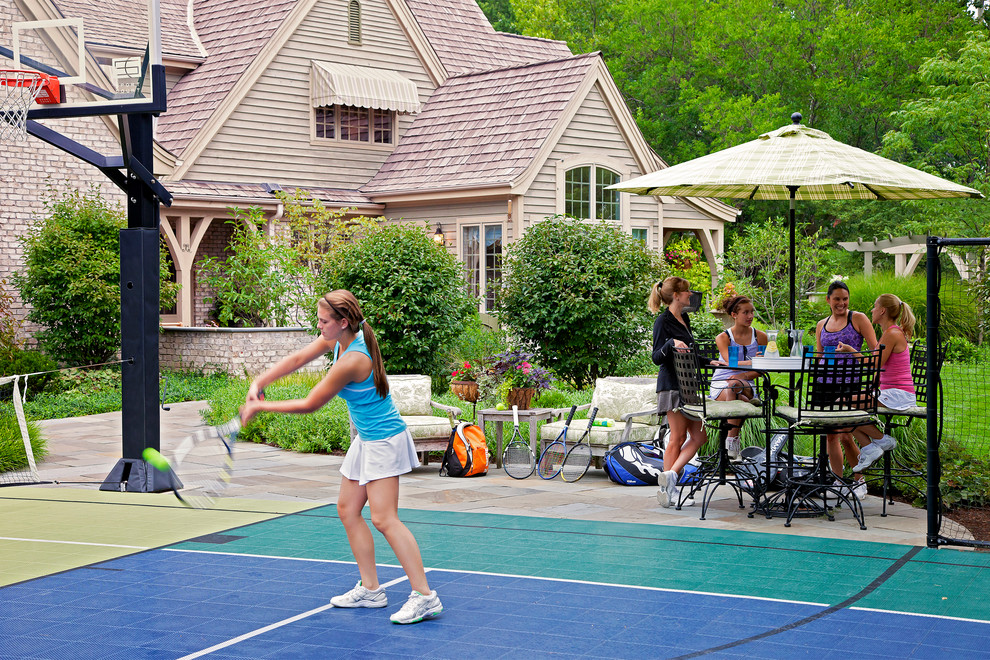 This is an example of a large traditional backyard full sun outdoor sport court for summer in Chicago with natural stone pavers.