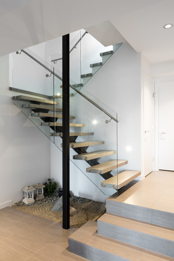 This is an example of a mid-sized contemporary wood floating staircase in Vancouver with wood risers.