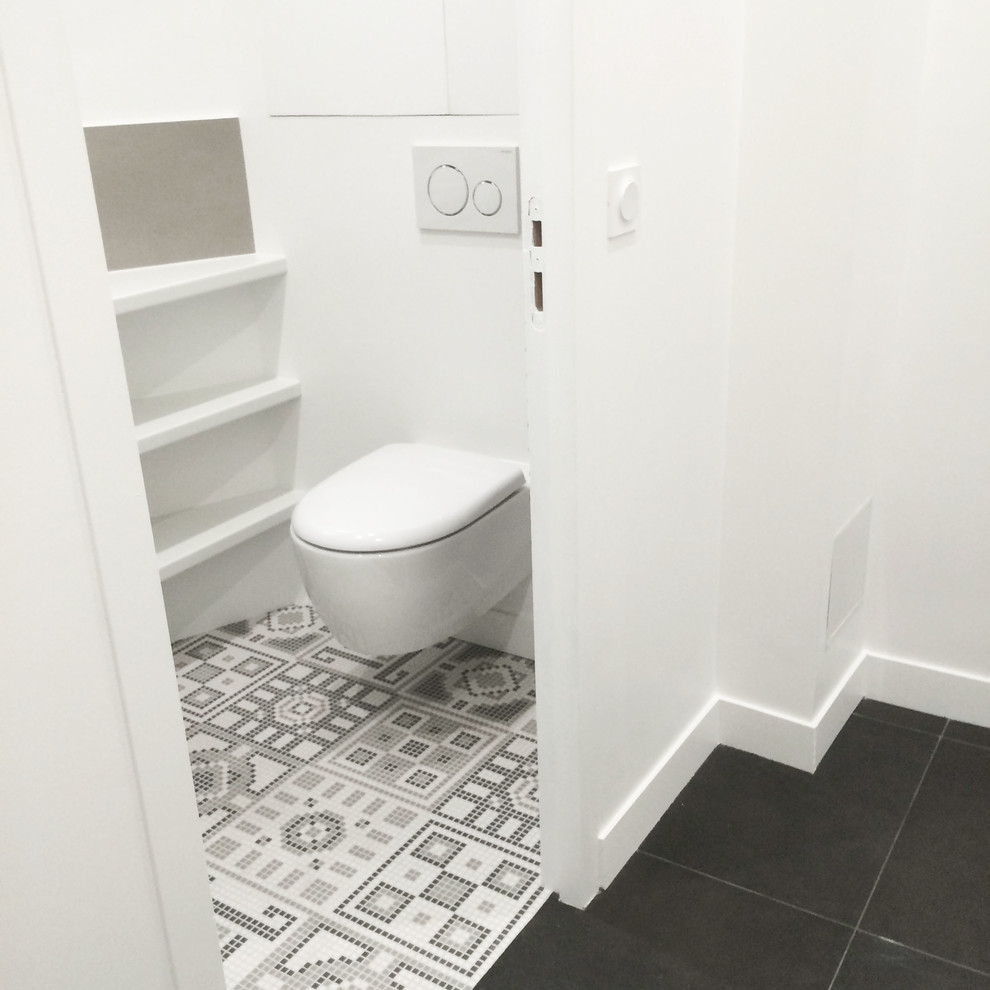 Design ideas for a small contemporary powder room in Paris with a wall-mount toilet and mosaic tile floors.