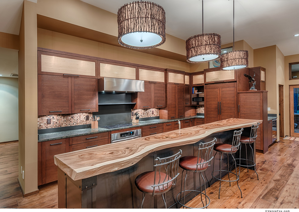 Mid-sized transitional l-shaped medium tone wood floor open concept kitchen photo with a drop-in sink, flat-panel cabinets, medium tone wood cabinets, brown backsplash, ceramic backsplash, paneled appliances, two islands and wood countertops