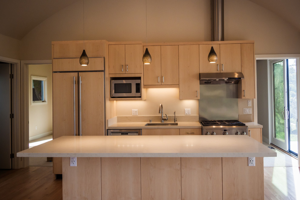 This is an example of a small contemporary single-wall eat-in kitchen in San Francisco with an undermount sink, flat-panel cabinets, light wood cabinets, quartz benchtops, beige splashback, stone slab splashback, stainless steel appliances, light hardwood floors and with island.