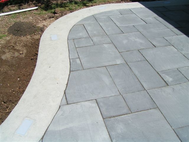 Inspiration for a mid-sized modern backyard patio in Milwaukee with natural stone pavers and no cover.