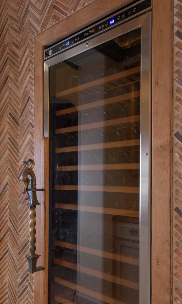 Inspiration for a mid-sized mediterranean wine cellar in San Diego with limestone floors and beige floor.