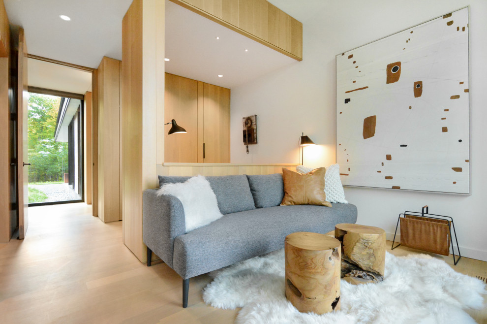 Großes Modernes Gästezimmer mit weißer Wandfarbe, hellem Holzboden, braunem Boden und Holzwänden in Sonstige
