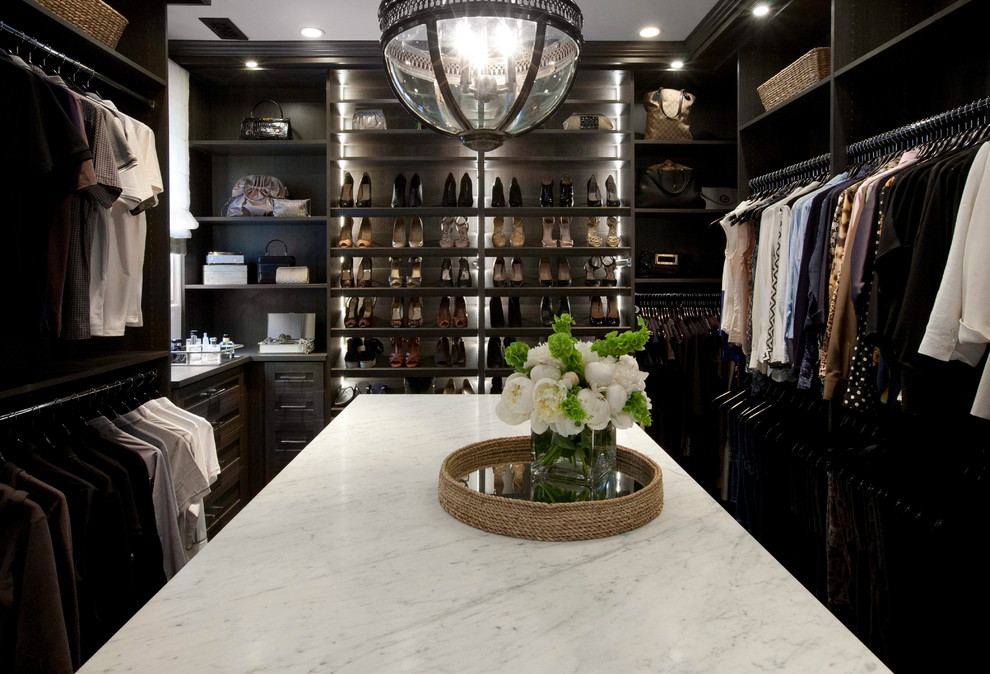 Photo of an expansive gender-neutral dressing room in Los Angeles with shaker cabinets, dark wood cabinets and dark hardwood floors.