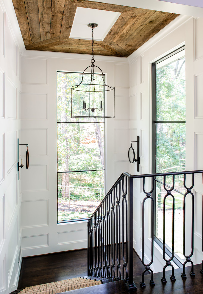 This is an example of a country wood staircase in Atlanta with metal railing.