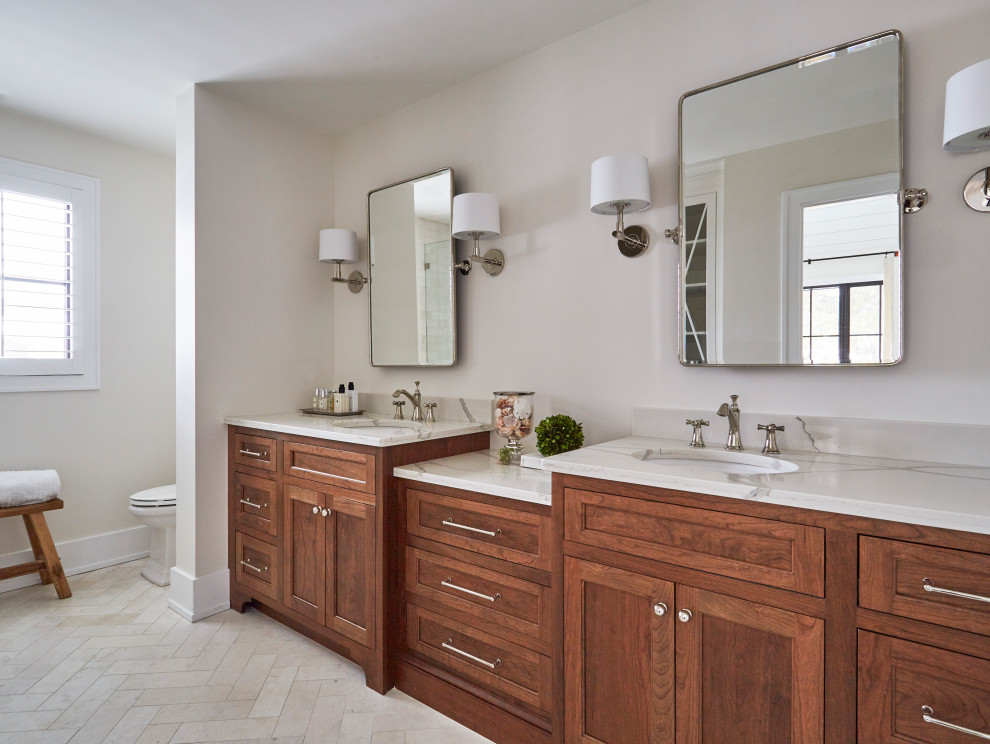 Mid-sized farmhouse master beige tile and marble tile marble floor, beige floor and double-sink alcove shower photo in Chicago with brown cabinets, a two-piece toilet, white walls, an undermount sink, quartz countertops, a hinged shower door, white countertops, a built-in vanity and shaker cabinets