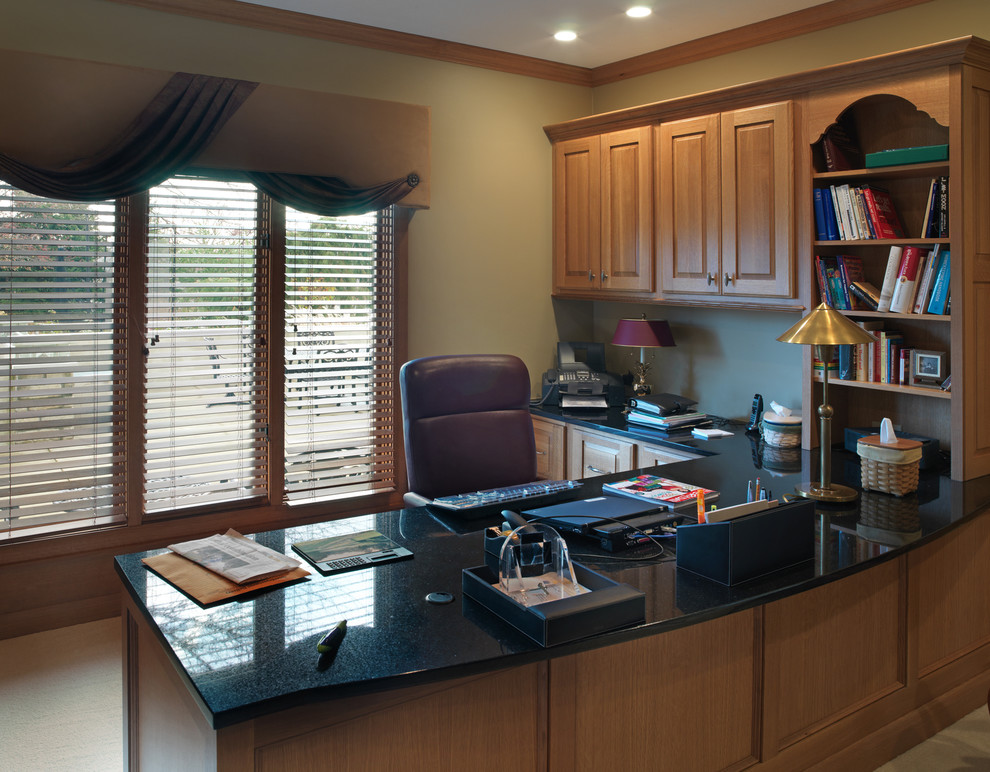 This is an example of a traditional home office in Columbus with green walls, carpet and a freestanding desk.