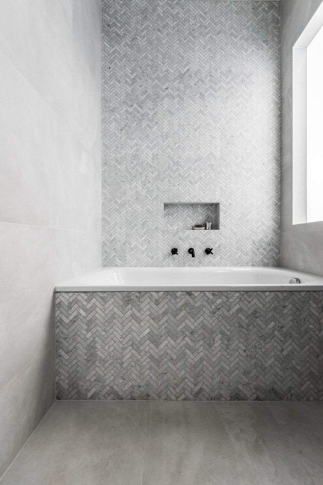 Inspiration for a mid-sized contemporary master wet room bathroom in Melbourne with flat-panel cabinets, dark wood cabinets, a drop-in tub, a one-piece toilet, gray tile, porcelain tile, grey walls, porcelain floors, an integrated sink, solid surface benchtops, grey floor and a hinged shower door.