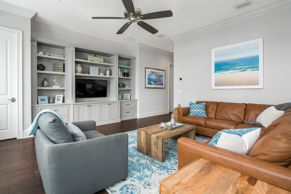 Inspiration for a large beach style enclosed living room in Orlando with dark hardwood floors, no fireplace, a wall-mounted tv, brown floor and grey walls.
