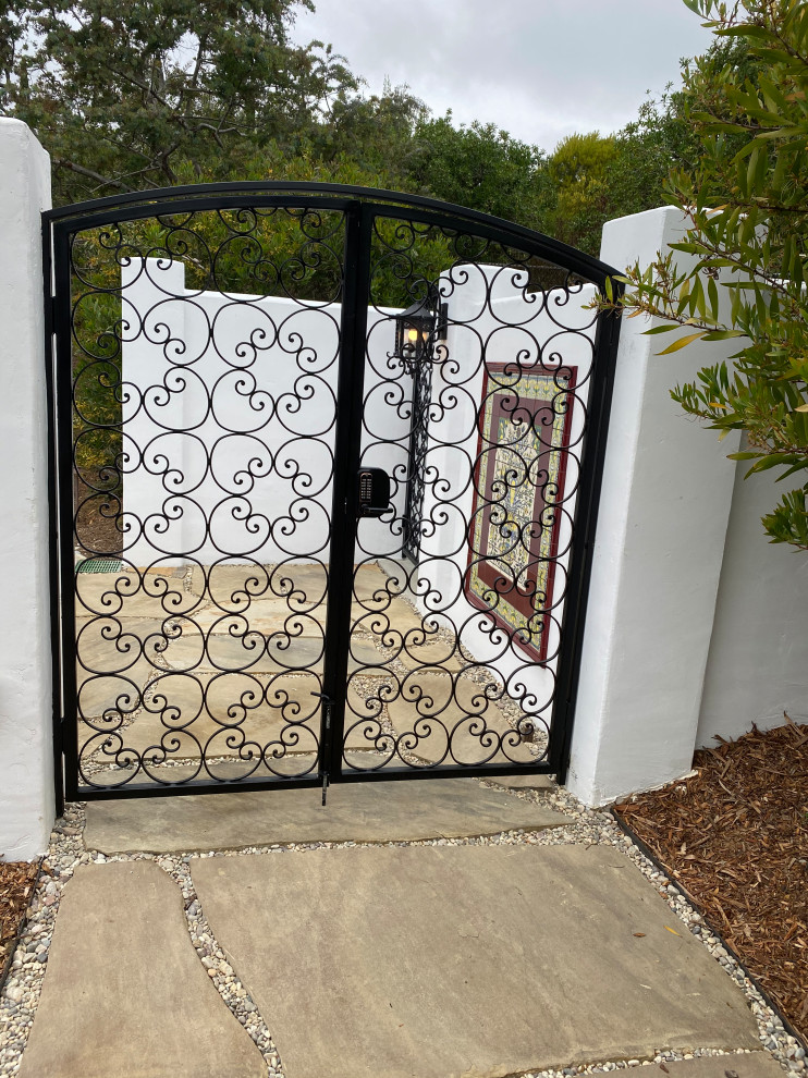 Expansive mediterranean back formal full sun garden for summer in San Diego with a gate and natural stone paving.